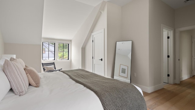 3148 Mountain Rd Unit B, Stowe, VT 05672 - bedroom with light wood-type flooring and lofted ceiling