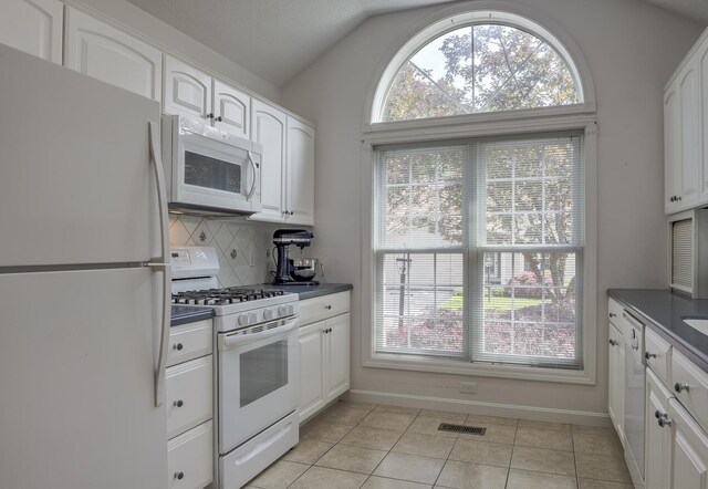 53 Summit Ridge Dr, Keene, NH 03431 - kitchen with white appliances, dark countertops, lofted ceiling, plenty of natural light, and white cabinets
