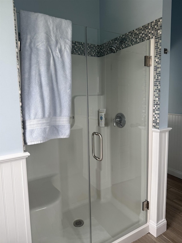 30 River St, Seabrook, NH 03874 - full bathroom featuring a shower stall, a wainscoted wall, and wood finished floors