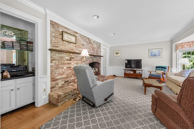 5 Melendy Holw, Amherst, NH 03031 - living area with crown molding, a wainscoted wall, light wood-style floors, a fireplace, and a textured ceiling