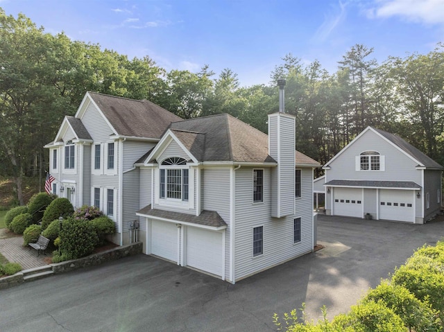 8 Aulson Rd, Salem, NH 03079 - view of front of house with a chimney, a shingled roof, view of scattered trees, and a detached garage