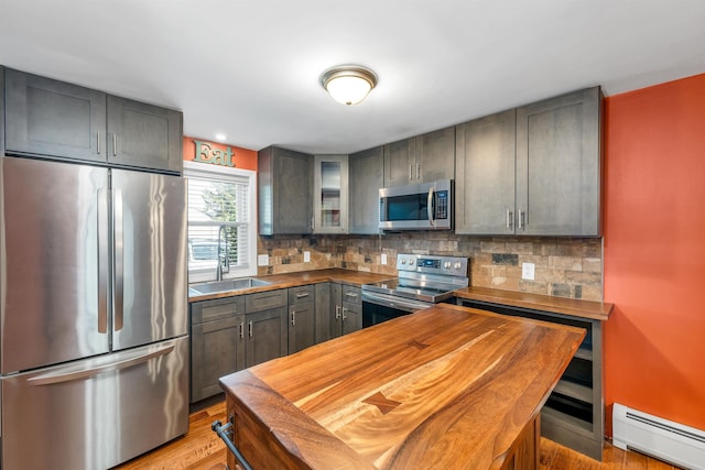 31 Bluffs Dr, Concord, NH 03303 - kitchen featuring stainless steel appliances, a baseboard heating unit, wooden counters, backsplash, and glass insert cabinets