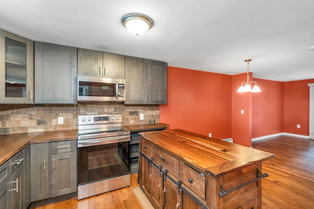31 Bluffs Dr, Concord, NH 03303 - kitchen with stainless steel appliances, butcher block counters, tasteful backsplash, light wood-style flooring, and a chandelier