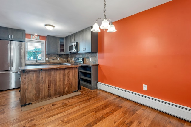 31 Bluffs Dr, Concord, NH 03303 - kitchen featuring appliances with stainless steel finishes, a baseboard heating unit, backsplash, light wood-type flooring, and glass insert cabinets