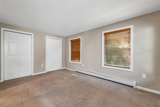 31 Bluffs Dr, Concord, NH 03303 - unfurnished bedroom featuring a baseboard heating unit, two closets, and carpet