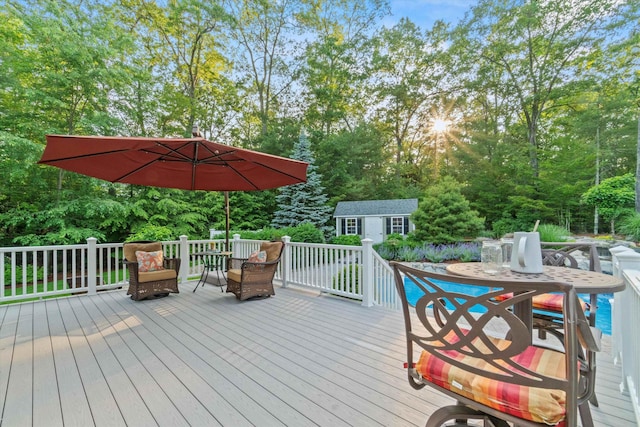 104 Windsor Dr, Auburn, NH 03032 - deck featuring an outdoor structure, outdoor dining space, and view of wooded area