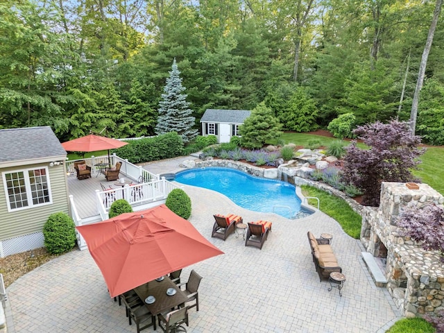 104 Windsor Dr, Auburn, NH 03032 - swimming pool with outdoor dining space, a wooden deck, an outdoor structure, and a patio area