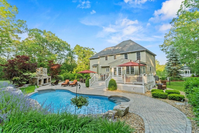 104 Windsor Dr, Auburn, NH 03032 - rear view of house with an outdoor stone fireplace, a wooden deck, a patio area, and an outdoor pool