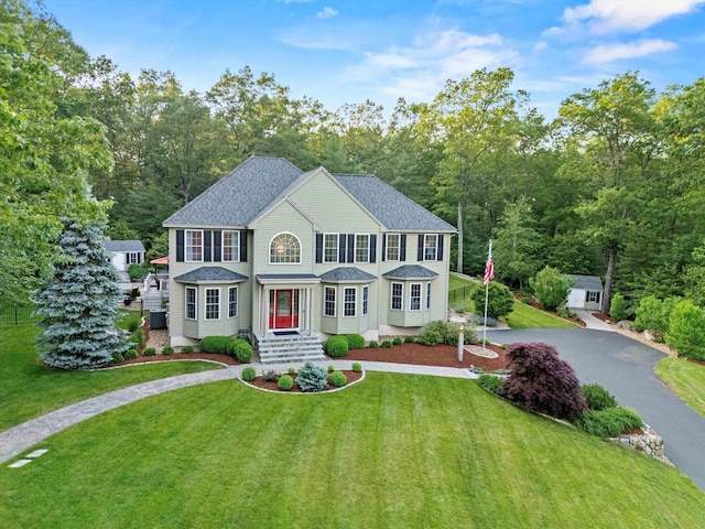 104 Windsor Dr, Auburn, NH 03032 - colonial-style house featuring driveway, a front lawn, and roof with shingles