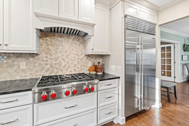 104 Windsor Dr, Auburn, NH 03032 - kitchen with appliances with stainless steel finishes, premium range hood, ornamental molding, decorative backsplash, and wood finished floors