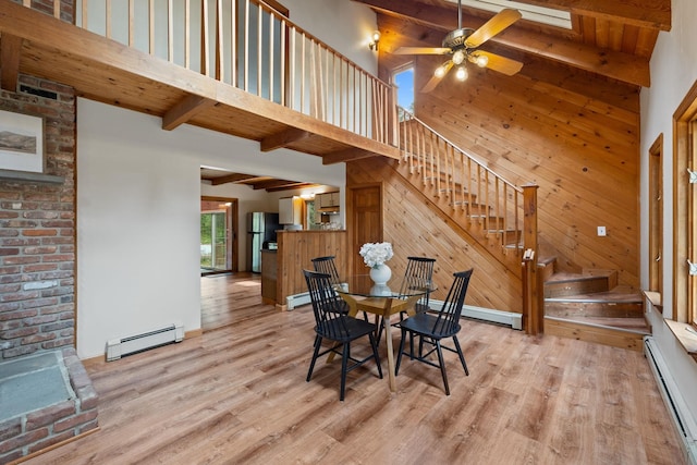 26 Old Mill Rd, Ossipee, NH 03890 - dining space featuring a baseboard heating unit, stairs, beamed ceiling, light wood-type flooring, and baseboard heating