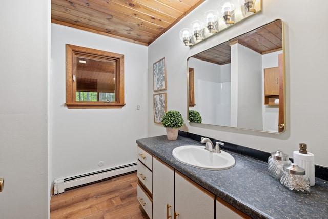 26 Old Mill Rd, Ossipee, NH 03890 - bathroom with a baseboard heating unit, wood ceiling, vanity, and wood finished floors