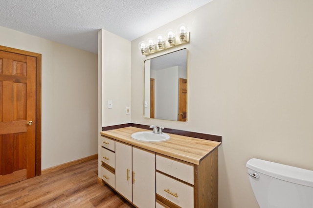 26 Old Mill Rd, Ossipee, NH 03890 - half bathroom with vanity, wood finished floors, and a textured ceiling