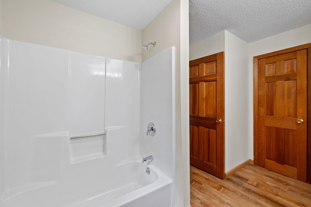 26 Old Mill Rd, Ossipee, NH 03890 - bathroom with wood finished floors, washtub / shower combination, and a textured ceiling