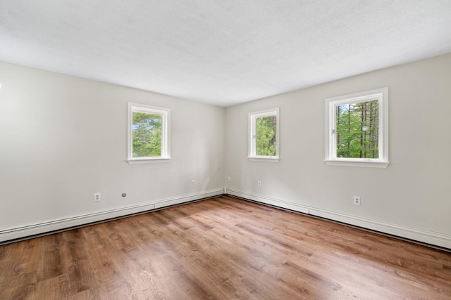 26 Old Mill Rd, Ossipee, NH 03890 - empty room with wood finished floors and a baseboard radiator