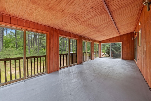 26 Old Mill Rd, Ossipee, NH 03890 - unfurnished sunroom with wooden walls, lofted ceiling, wood ceiling, and concrete flooring