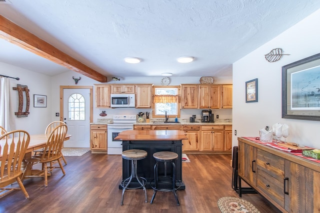 895 Head Of The Pond Rd, Brighton, VT 05846 - kitchen with white appliances, dark wood-style floors, light brown cabinetry, a kitchen bar, and healthy amount of natural light