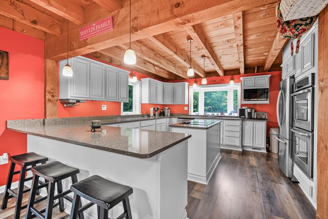 329 Peverly Rd, Northfield, NH 03276 - kitchen featuring a wood ceiling with exposed beams, a peninsula, healthy amount of natural light, built in microwave, and double oven
