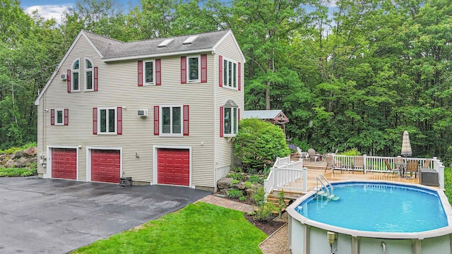 329 Peverly Rd, Northfield, NH 03276 - view of front facade featuring a deck, asphalt driveway, an outdoor pool, a garage, and roof with shingles