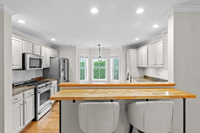 243 Drakeside Rd Unit 7, Hampton, NH 03842 - kitchen featuring stainless steel appliances, wood counters, ornamental molding, recessed lighting, and a peninsula