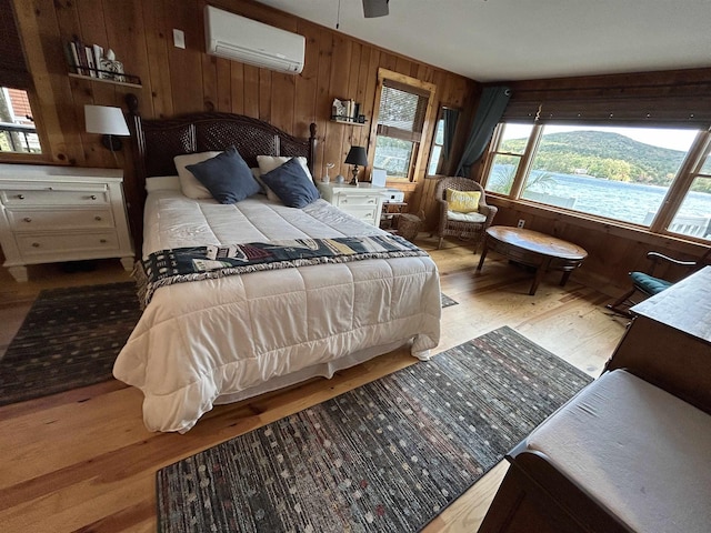352 S Shore Rd, New Durham, NH 03855 - bedroom featuring an AC wall unit, wood finished floors, and wooden walls