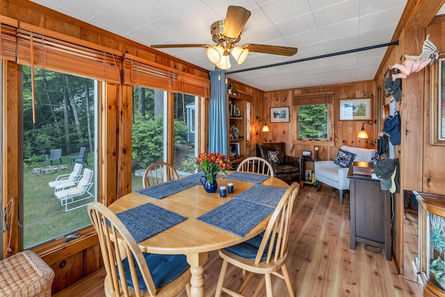 352 S Shore Rd, New Durham, NH 03855 - dining area featuring light wood-style flooring, wood walls, and ceiling fan