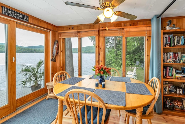 352 S Shore Rd, New Durham, NH 03855 - dining room featuring wood walls, plenty of natural light, a water view, and a ceiling fan