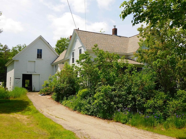 336 Main St, Wakefield, NH 03887 - view of side of property with a chimney and a shingled roof