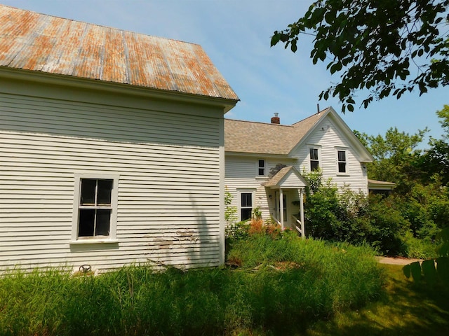 336 Main St, Wakefield, NH 03887 - view of side of home featuring a metal roof and a chimney
