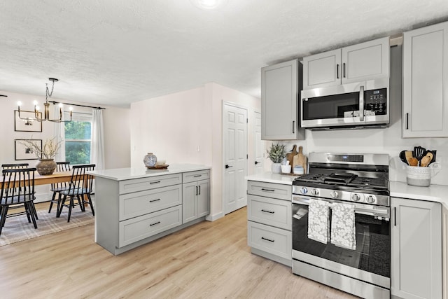 15 Wildflower Dr, Concord, NH 03303 - kitchen featuring appliances with stainless steel finishes, gray cabinetry, light wood-style flooring, light countertops, and a textured ceiling