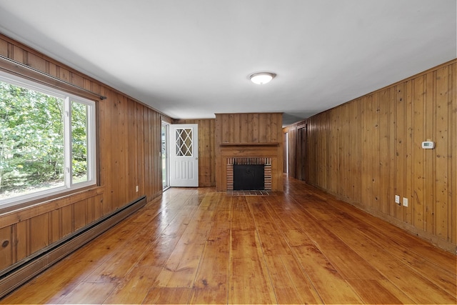 27 Mason Rd, Brookline, NH 03033 - unfurnished living room with baseboard heating, light wood finished floors, a brick fireplace, and wooden walls