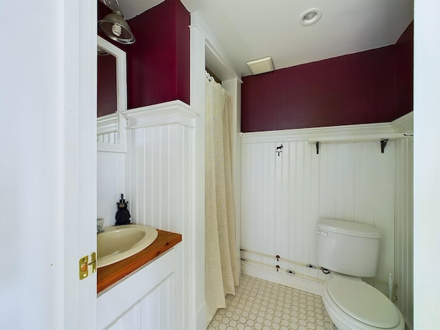 312 Roy Rd, Stewartstown, NH 03576 - bathroom featuring a wainscoted wall, tile patterned floors, vanity, a decorative wall, and a shower with curtain