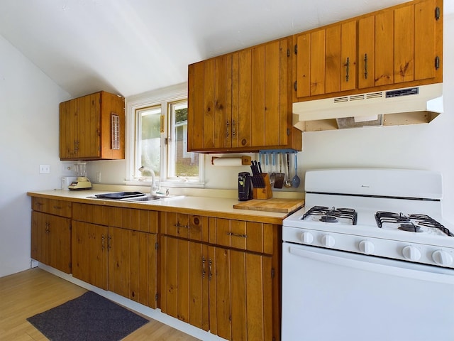 312 Roy Rd, Stewartstown, NH 03576 - kitchen featuring white range with gas cooktop, under cabinet range hood, brown cabinets, light countertops, and lofted ceiling