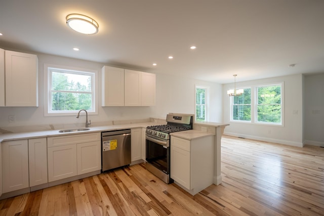 51 Spruce Rd, Middleton, NH 03887 - kitchen featuring stainless steel appliances, a peninsula, light wood-style flooring, light countertops, and white cabinets