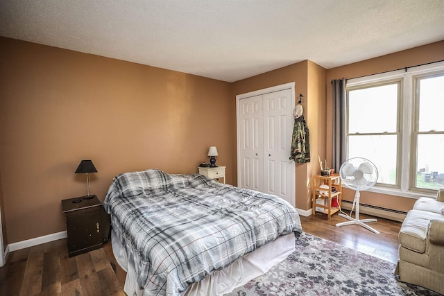 19 Shelburne Rd Unit 19, Merrimack, NH 03054 - bedroom featuring dark wood finished floors, baseboard heating, a closet, and a textured ceiling