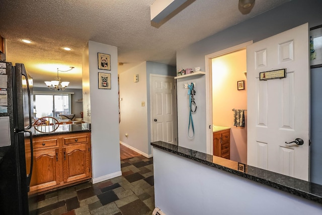 19 Shelburne Rd Unit 19, Merrimack, NH 03054 - kitchen featuring freestanding refrigerator, brown cabinets, a chandelier, a textured ceiling, and recessed lighting