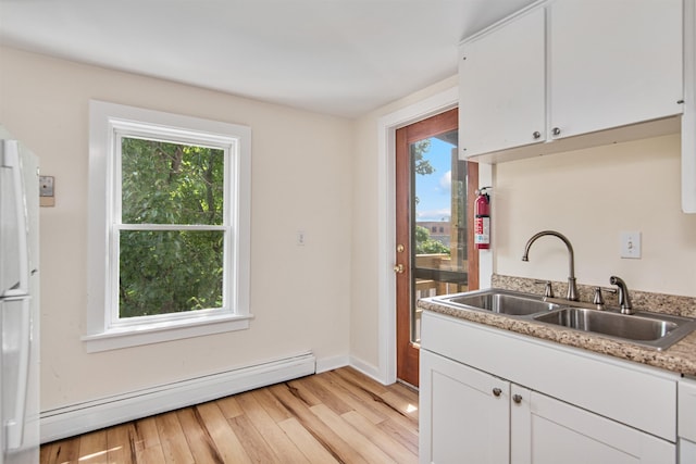 89 College St Unit A-2, Burlington, VT 05401 - kitchen featuring baseboard heating, light wood-style flooring, white cabinets, freestanding refrigerator, and light countertops