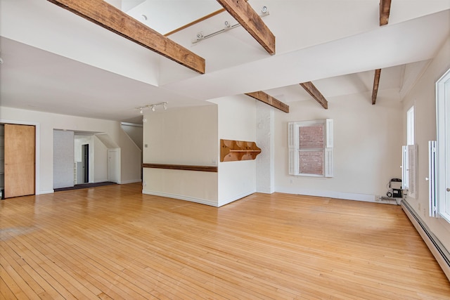 89 College St Unit A-2, Burlington, VT 05401 - unfurnished living room featuring a baseboard radiator, rail lighting, beam ceiling, and hardwood / wood-style floors