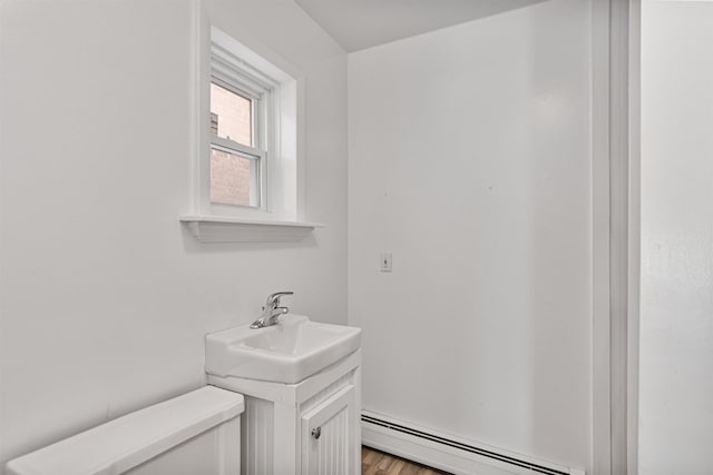 89 College St Unit A-2, Burlington, VT 05401 - half bath featuring a baseboard radiator, vanity, and wood finished floors
