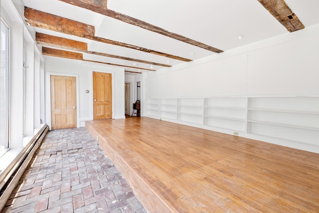 526 River Rd, Lyme, NH 03768 - empty room with a baseboard heating unit, beam ceiling, and brick flooring