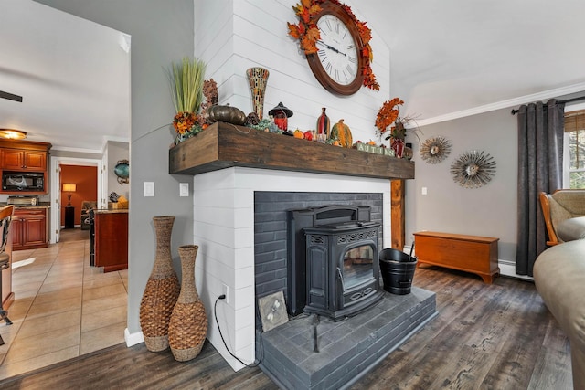55 Trask Side Rd, Alton, NH 03810 - living area with a wood stove, ornamental molding, light wood-type flooring, and a baseboard heating unit