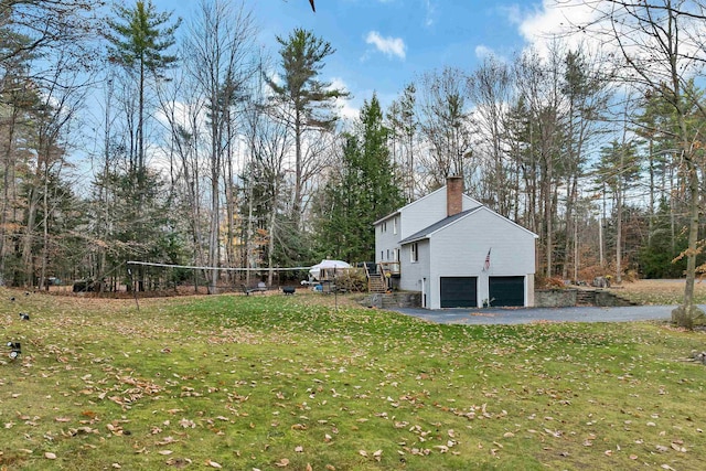 55 Trask Side Rd, Alton, NH 03810 - view of side of property featuring an attached garage, a chimney, driveway, and a lawn