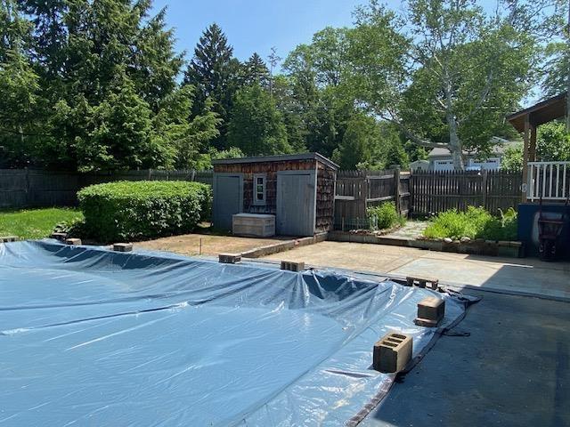 15 Vernon Ave, Rochester, NH 03867 - view of swimming pool featuring a storage unit, a fenced backyard, and a patio