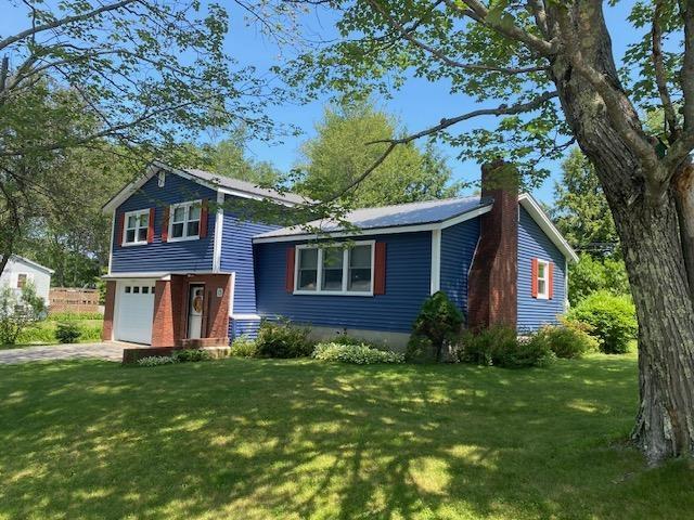 15 Vernon Ave, Rochester, NH 03867 - tri-level home with an attached garage, a front yard, a chimney, and driveway