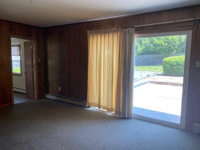 15 Vernon Ave, Rochester, NH 03867 - unfurnished room with a baseboard heating unit, carpet, and wooden walls