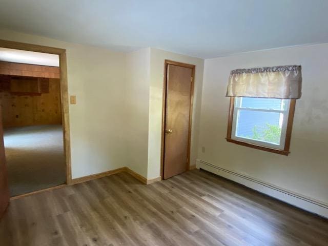 15 Vernon Ave, Rochester, NH 03867 - empty room with a baseboard radiator and wood finished floors