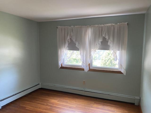 15 Vernon Ave, Rochester, NH 03867 - spare room featuring baseboard heating, healthy amount of natural light, and wood finished floors