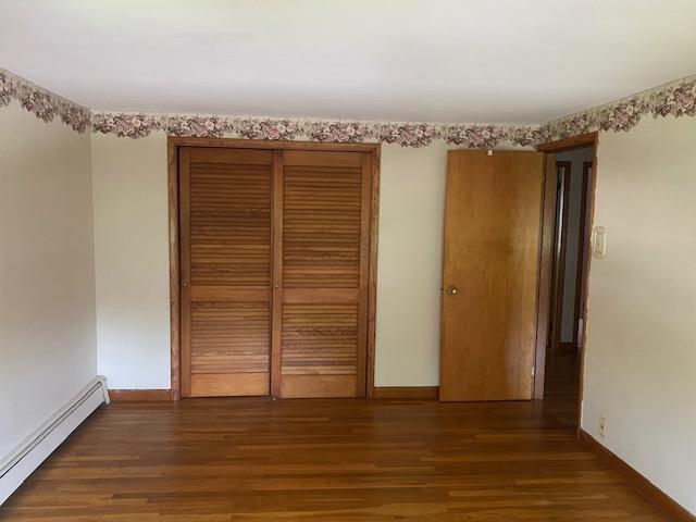 15 Vernon Ave, Rochester, NH 03867 - unfurnished bedroom with a baseboard radiator, wood finished floors, and a closet