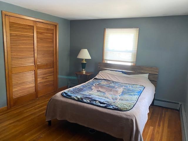 15 Vernon Ave, Rochester, NH 03867 - bedroom with wood finished floors, a baseboard heating unit, and a closet