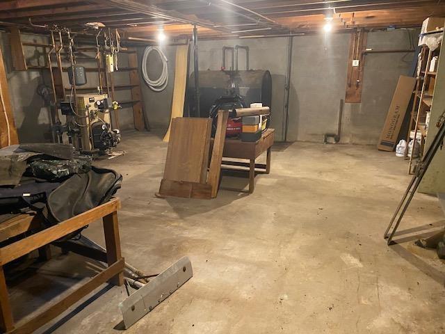 15 Vernon Ave, Rochester, NH 03867 - unfinished below grade area featuring a heating unit and oil tank